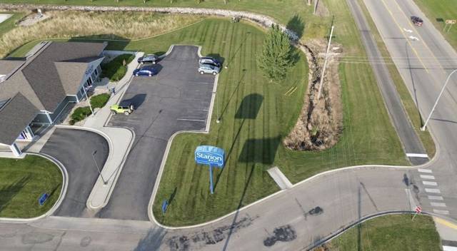 Aerial view of striped commercial grounds beside a parking lot and road