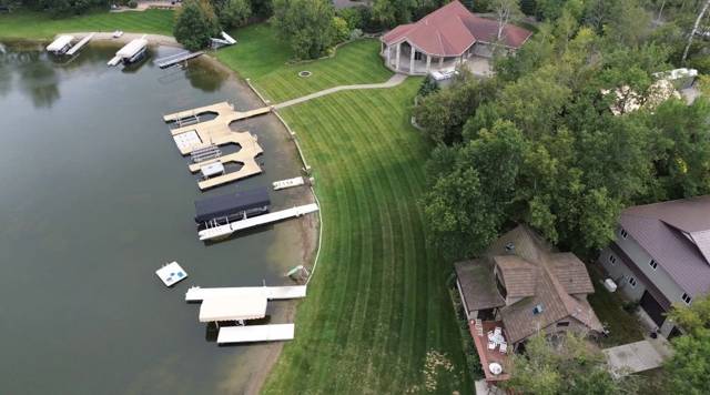 Aerial view of a curved, striped lawn running along a lakeshore lined with docks