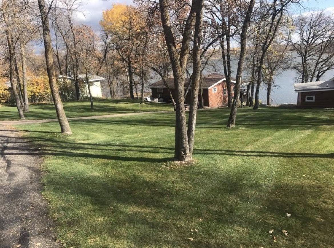 The same lake cabin yard after cleanup, leaves gone and lawn mowed