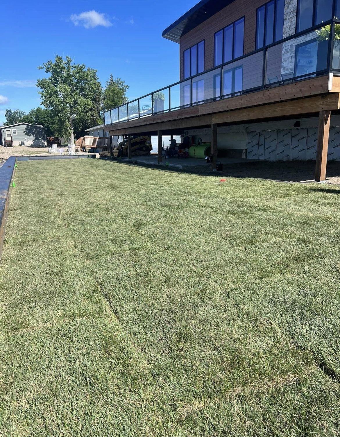 Fresh sod laid beside the same lake home deck